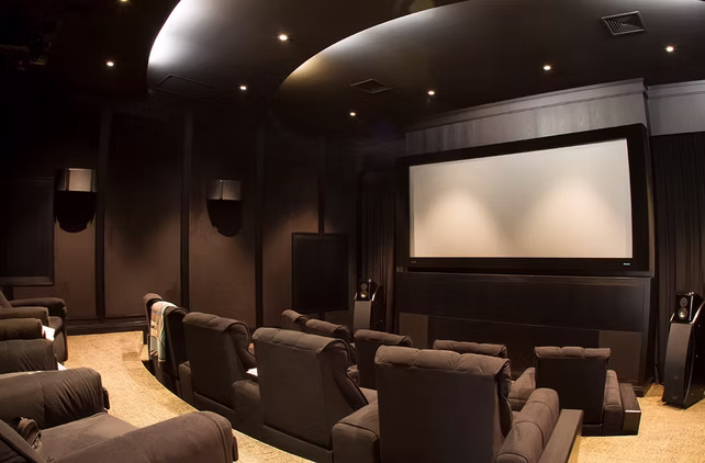 Home cinema do portfólio, com projeção, poltronas e iluminação indireta
